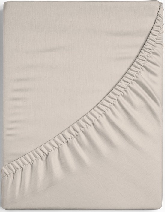 Drap-housse beige avec élastique sur un côté, montrant la texture du tissu.