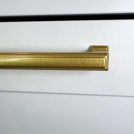 Gouden roestvrijstalen handgreep op een witte kast.