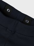 Gedetailleerde close-up van de tailleband van een donkerblauwe joggingbroek met verstelbare knopen.