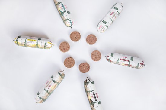 Zeven worstjes van KIVO petfood en schijfjes vlees op een witte achtergrond, in een cirkelvorm.