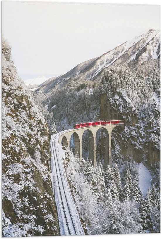 WallClassics - Vlag - Rode Trein door de Bergen in de Sneeuw - 50x75 cm Foto op Polyester Vlag
