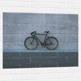 WallClassics - Muursticker - Zwarte Fiets tegen Grijze Gebouw - 100x75 cm Foto op Muursticker