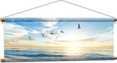 WallClassics - Textielposter - Meeuwen boven het Strand en Zee - 90x30 cm Foto op Textiel