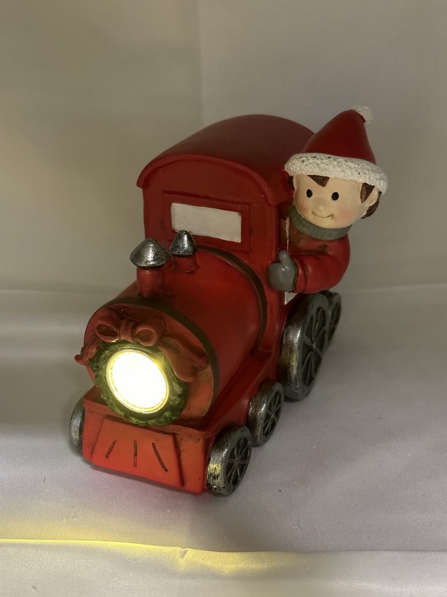 Kerstbeeldje jongen in rode trein met LED - rood & groen cadeau - polyresin - 13 cm hoog x 16 cm x 5 cm – Kerstdecoratie