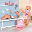 Een baby Born pop ligt op een bankje, een andere baby Born pop met masker geeft deze een thermometer.