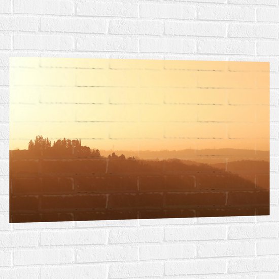 WallClassics - Muursticker - Mistig Heuvel Landschap met Opkomende Zon - 105x70 cm Foto op Muursticker