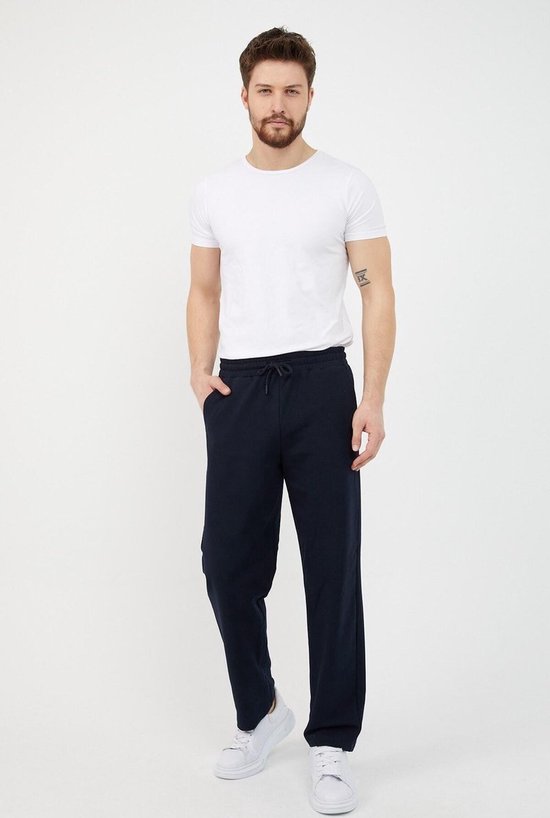 Donkerblauwe joggingbroek met trekkoord, gedragen door een man met een wit T-shirt en witte sneakers.