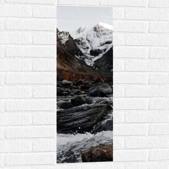 WallClassics - Muursticker - Water Stromend Langs Stenen - 30x90 cm Foto op Muursticker