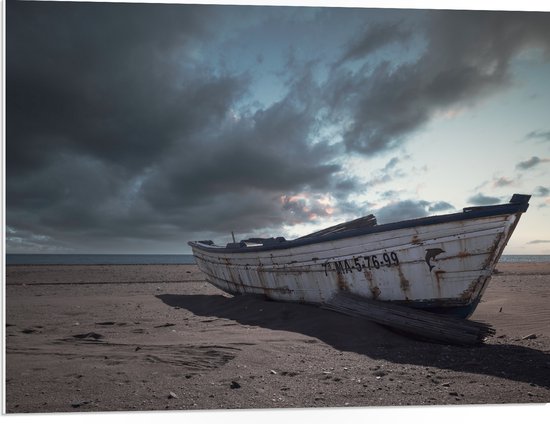 WallClassics - PVC Schuimplaat- Witte Boot op het Strand onder Donkere Wolken - 80x60 cm Foto op PVC Schuimplaat