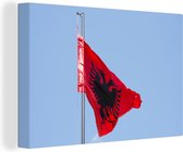 Canvas Schilderij Nationale vlag van Albanië op een heldere blauwe hemel - 90x60 cm - Wanddecoratie