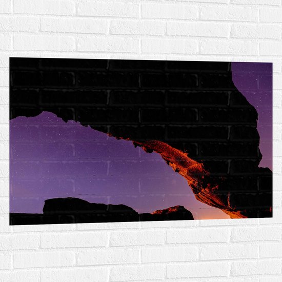 Muursticker - Silhouet van Grote Rots onder Sterrenhemel met Paarse Gloed - 105x70 cm Foto op Muursticker