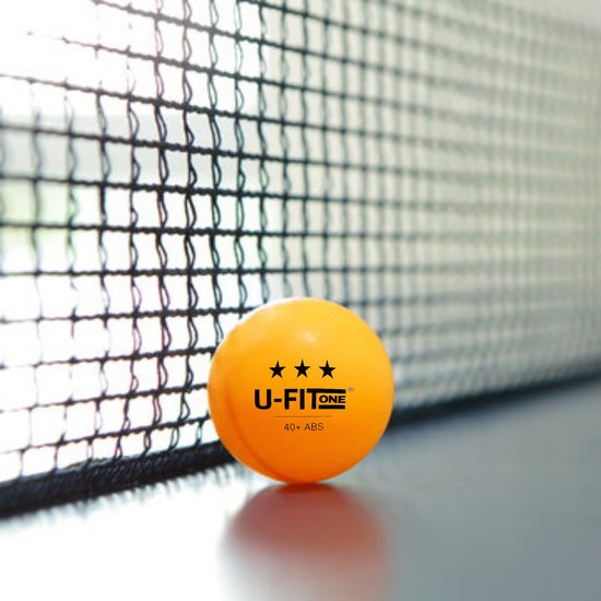 Een oranje U-FITONE tafeltennisbal met logo en 40+ ABS op een tafel voor de net.