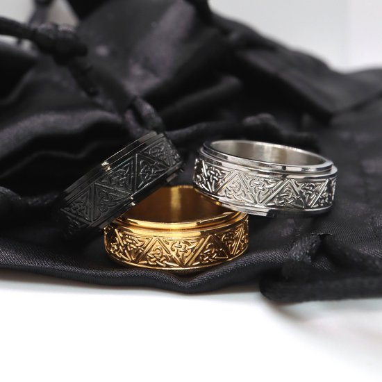 Drie draaibare ringen, zilverkleurig, goudkleurig en zwart, met Keltisch patroon.