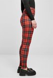 Zij-aanzicht van een vrouw in een rode ruit legging en zwarte loafers.