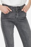 Close-up van de voorkant van een grijze jeans, met handen in de zakken.