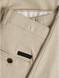 Detail van crèmekleurige chino broek met textuur, zakken en knoopsluiting, Jack & Jones logo.