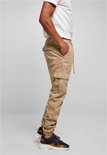 Man in beige cargo broek, zijdezichtbaar, met trekkoord, zakken en elastische enkelbanden.