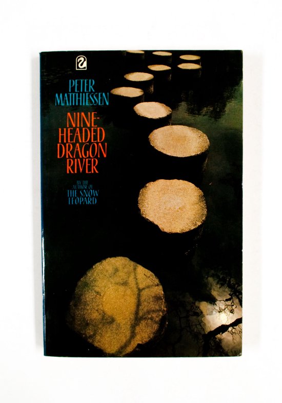 Boek kaft met tekst 'Nine Headed Dragon River' door Peter Matthiessen, met op de voorgrond een pad van ronde stenen over water.