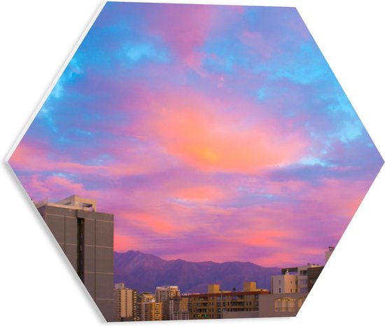 PVC Schuimplaat Hexagon - Felkleurige Lucht boven Gebouwen in het Blauw met Roze en Paars - 40x34.8 cm Foto op Hexagon (Met Ophangsysteem)