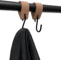 Bruine leren lussen met zwarte haken, waaraan een schaar en een grijze handdoek hangen.