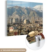 MuchoWow® Glasschilderij 120x90 cm - Schilderij acrylglas - Plaatje van Teheran met bergen op de achtergrond in Iran - Foto op glas - Schilderijen