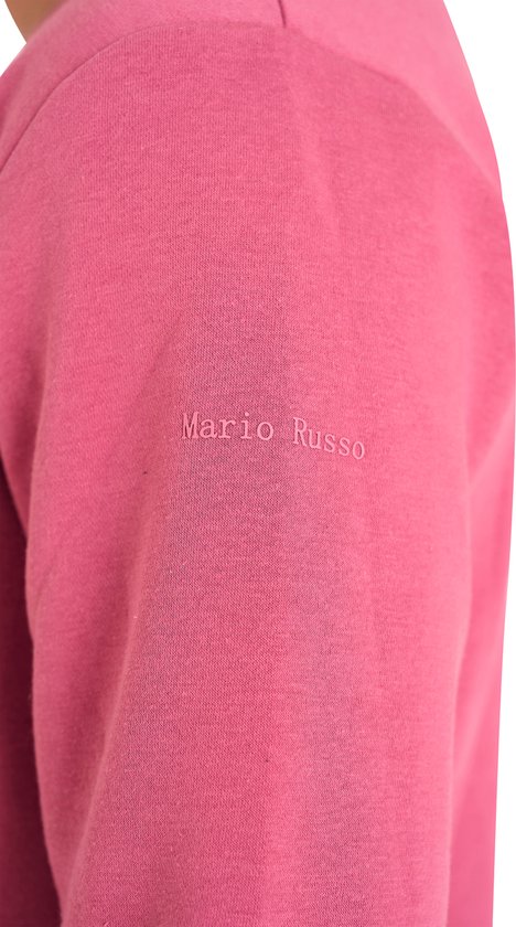 Close-up van oudroze trui met geborduurde tekst 'Mario Russo' op de mouw.
