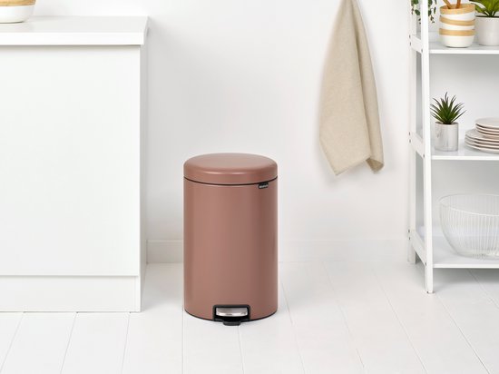 Bruine Brabantia NewIcon prullenbak met metalen trapper, staand in een keuken.