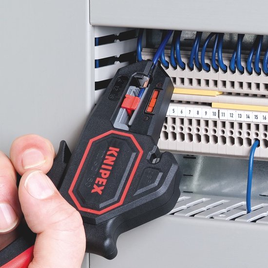 Knipex stripgereedschap met rode accenten, gebruikt om blauwe draad te strippen bij een schakelkast.