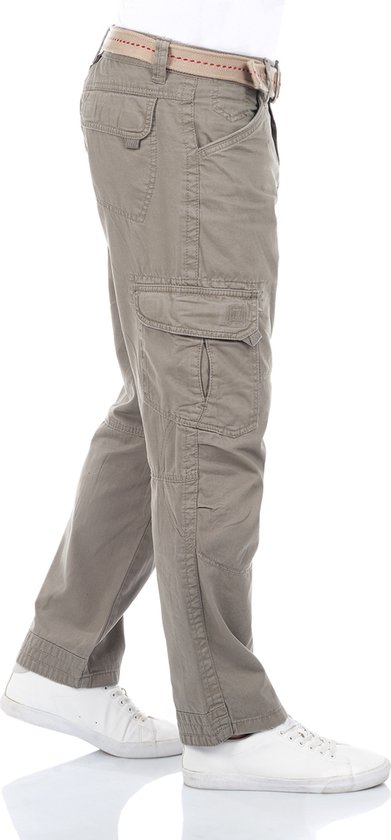 Man in grijze cargo broek met riem, cargozakken en witte sneakers, zichtbaar vanaf de zijkant.