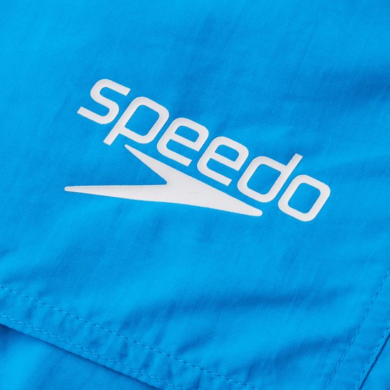 Détail du logo blanc Speedo sur un short de bain bleu.