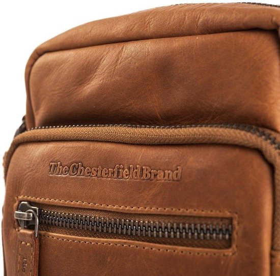 Close-up van het logo 'The Chesterfield Brand' op een bruine leren schoudertas.