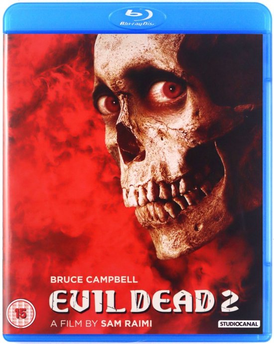 Evil Dead 2 Blu-ray hoes. Close-up van een skelet met rode ogen tegen een rode, rokerige achtergrond. Bevat de filmtitel en "A Film by Sam Raimi".