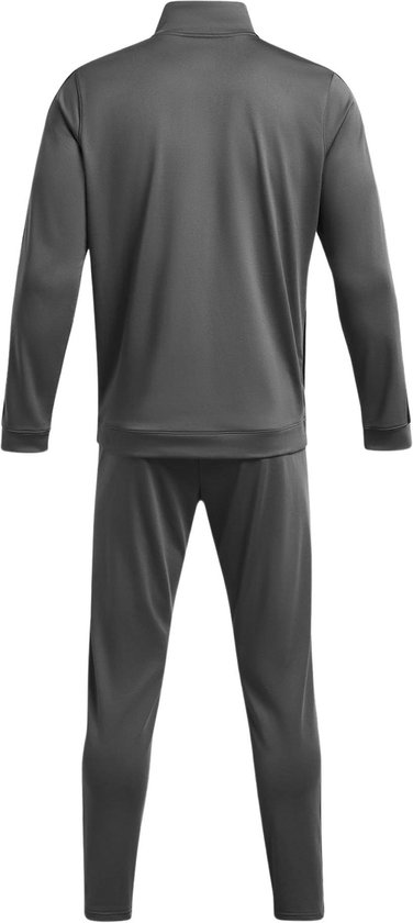 Achterkant van een grijs Under Armour trainingspak met zwarte strepen langs de buitenkant van de benen en mouwen.