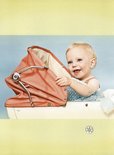Een baby met blond haar zit lachend in een vintage kinderwagen met oranje kap.