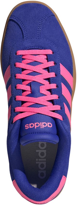 Bovenaanzicht van een blauwe Adidas sneaker met roze veters, roze strepen en een bruine zool.