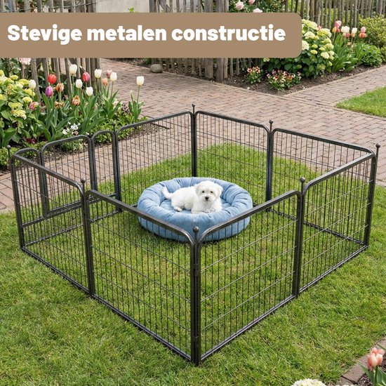 Zwarte metalen puppyren in de tuin met een witte puppy op een blauw kussen.