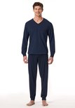 Man in donkerblauwe pyjamaset met fijn ruitpatroon op shirt met V-hals en effen broek.