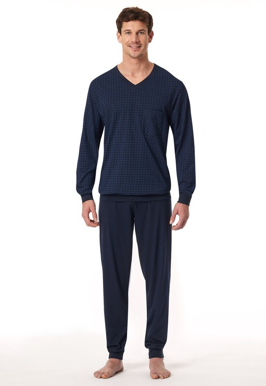 Man in donkerblauwe pyjamaset met fijn ruitpatroon op shirt met V-hals en effen broek.