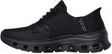 Zwarte Skechers damessneaker met mesh bovenwerk en een dikke, zwarte zool met uitsparingen. Slogan "SKECHERS SLIP-INS" op de zijkant.