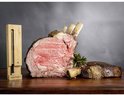 Geroosterde entrecote met botten en een stuk rundvlees ernaast, met een Meater+ thermometer en rozemarijntakjes.