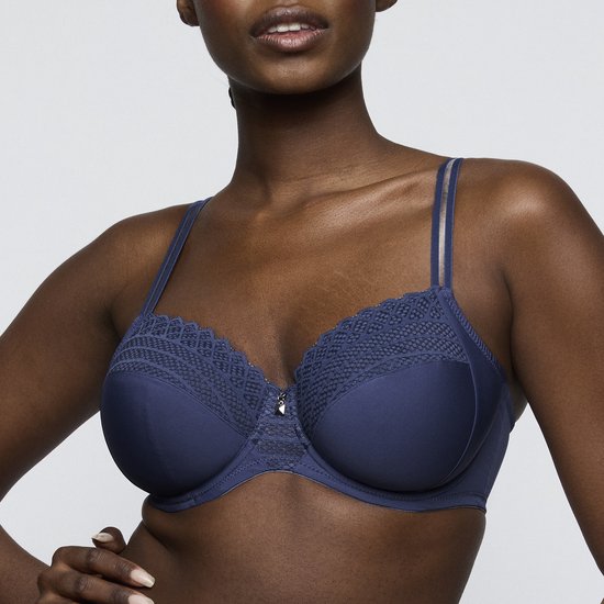 Close-up van een indigo blauwe PrimaDonna beugelbh met kanten bovenkant en een klein zilverkleurig bedeltje in het midden.
