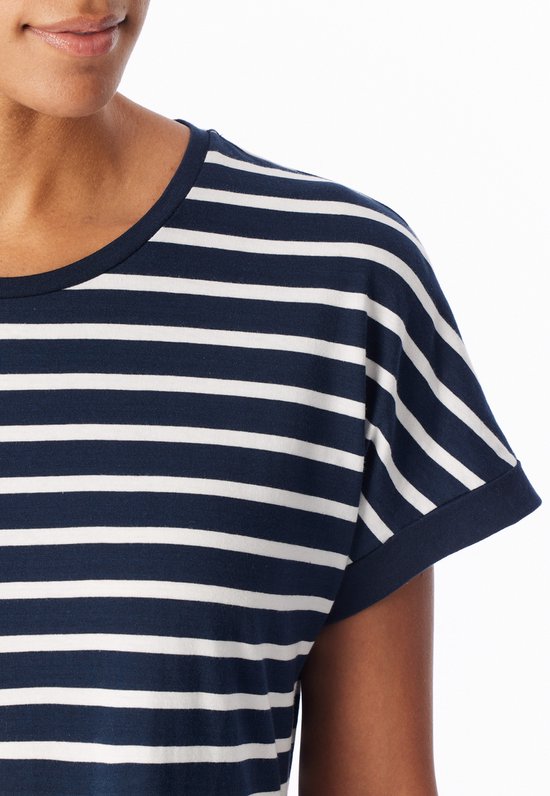 Close-up van een schouder en mouw van een donkerblauwe jurk met witte horizontale strepen.