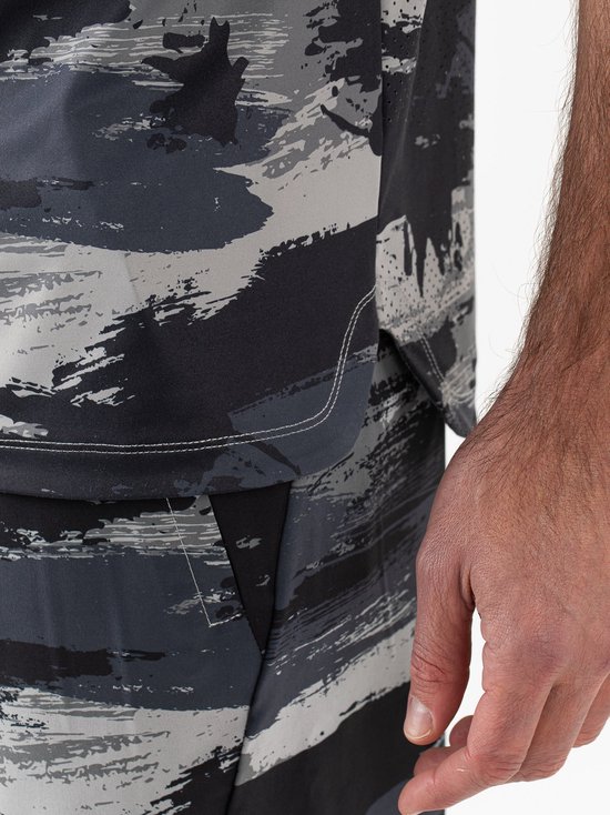 Heren sportbroek met camouflageprint in grijs en zwart, close-up van de stof en zak.