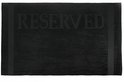 Zwarte handdoek met de tekst 'RESERVED' erop in reliëf.