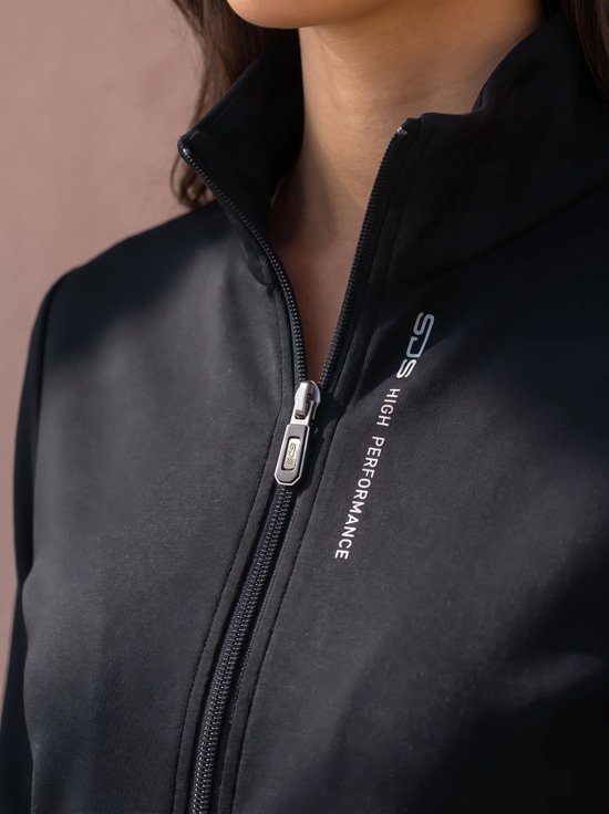 Detail van een zwarte sportvest met rits en 'Sjeng Sport High Performance' tekst.