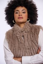Model met bruin, langharig imitatiebont gilet over witte blouse. Close-up van gezicht en bovenlichaam.