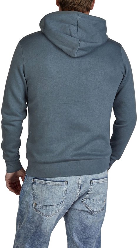 Achterkant van een blauwgrijze hoodie met capuchon, gedragen met spijkerbroek.