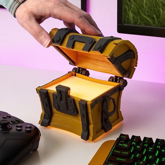 Een hand opent een houten kistlamp met metalen details en een zachte oranje gloed van binnen.