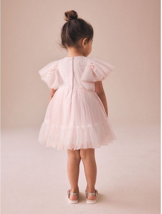 Meisje in een roze, off-shoulder mesh feestjurk met korte mouwen en bloemen-appliques, staand.