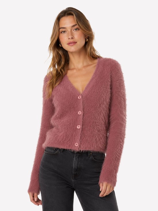 Een roze, wollige cardigan met V-hals en knoopsluiting, gedragen door een model met donkere jeans.